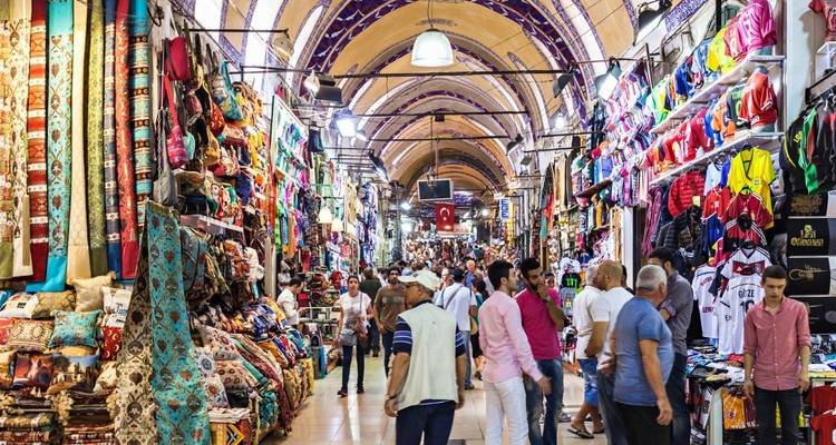 Bustling indoor market with colorful goods and many people.