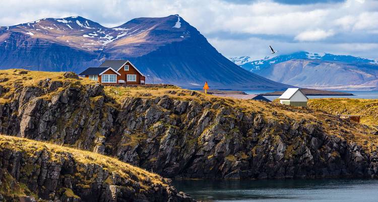Küstenlandschaft mit Häusern und Bergen.