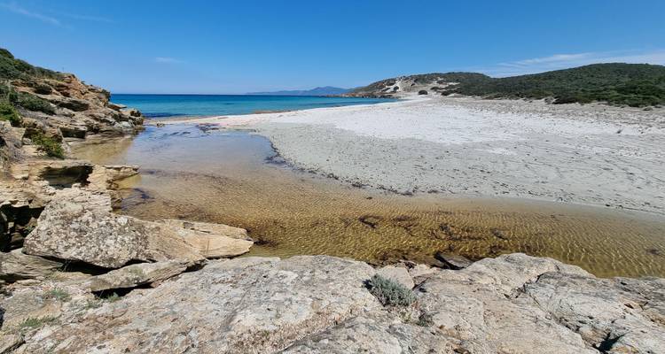 Remote coastal beach with clear blue waters.