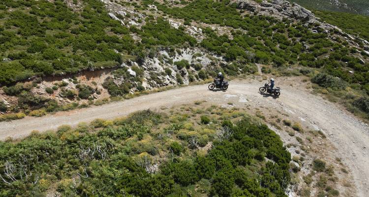 Two motorcycles on a winding mountain trail.