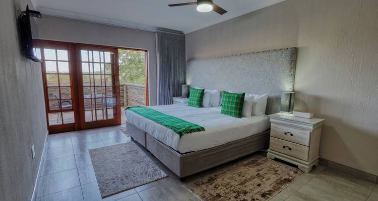 Bedroom with a large bed and balcony access.