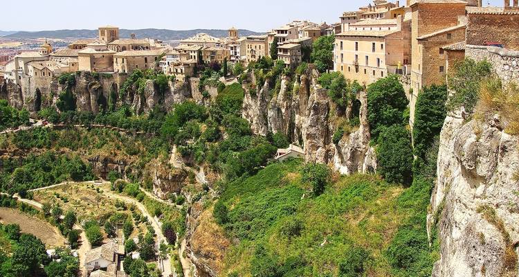Een uitgestrekte stad op ruige kliffen met weelderige begroeiing.