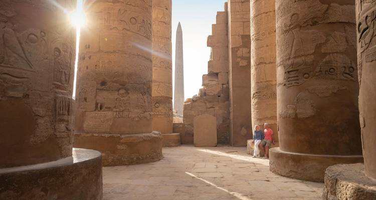 Touristen erkunden die antiken Ruinen mit beleuchteten Hieroglyphen.