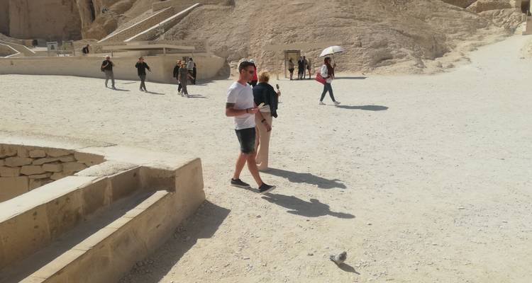 Des gens qui se promènent dans un site archéologique ensoleillé.