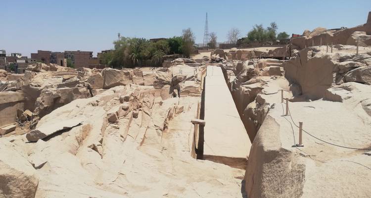 Site de carrière ouverte avec un grand obélisque couché au sol.