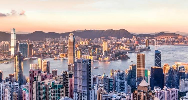 A wide view of Hong Kong's city skyline at sunset.