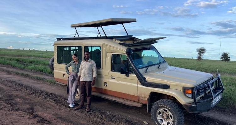 Mensen die naast een safariauto staan op een onverharde weg.