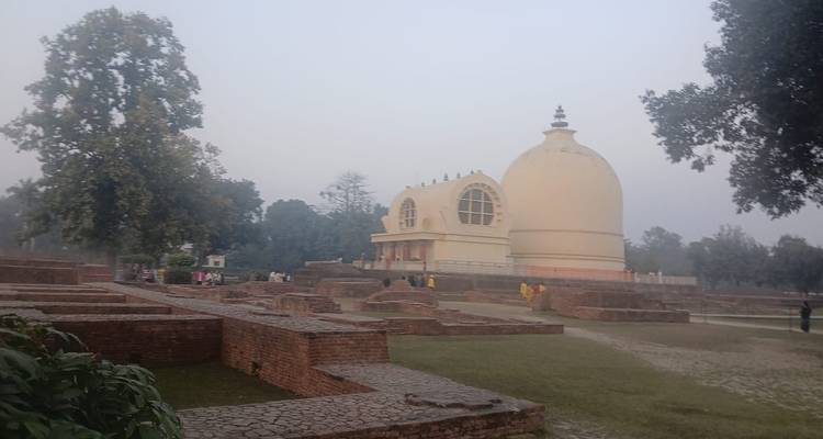 Kuppelförmiges Gebäude mit umliegendem Park bei Tageslicht.