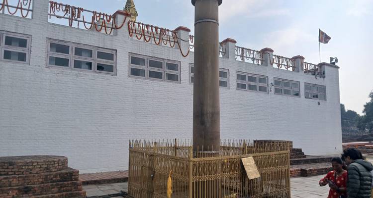 Parlamentssäule mit eingezäuntem Bereich und Besuchern.