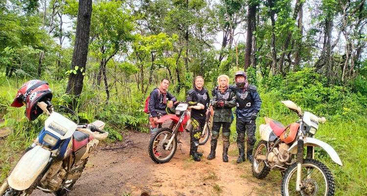 Groupe de motocyclistes dans une zone boisée.