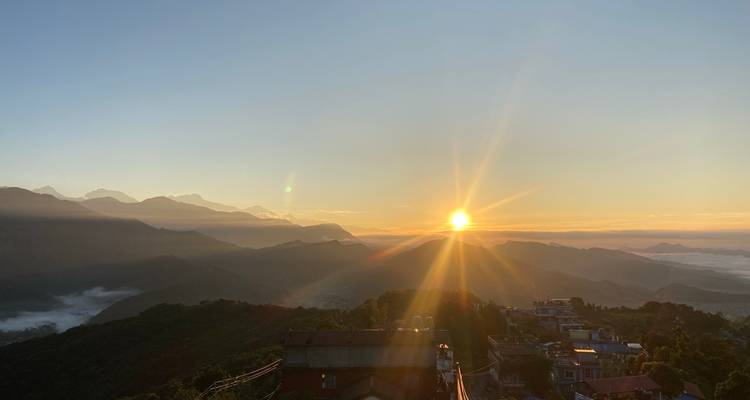 Lever de soleil sur un paysage montagneux avec des nuages.