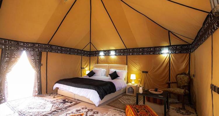 Interior lujoso de una tienda de glamping con comodidades modernas.