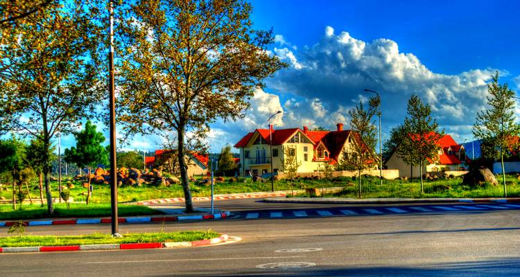 Pintoresca zona residencial con césped verde vibrante y tejados rojos.