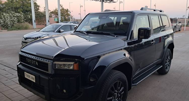 SUV Toyota negro estacionado en un estacionamiento al atardecer.