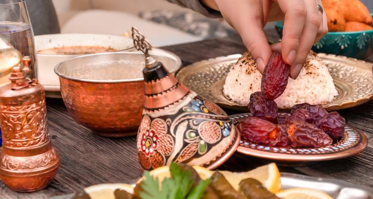 A variety of Moroccan dishes are displayed, including dates and traditional utensils.
