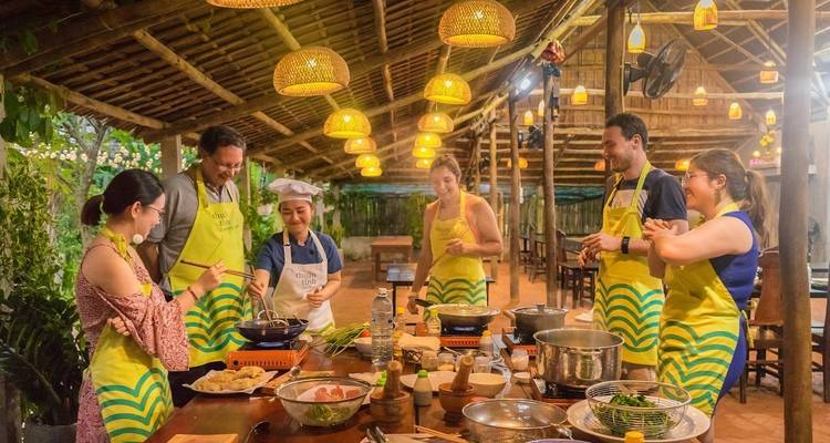 Clase de cocina grupal bajo una estructura tradicional de madera.