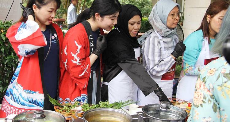 Mujeres en vestimenta tradicional participando en una clase de cocina.