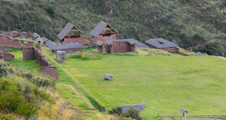 Traditionele constructies op een helling met groen gras.