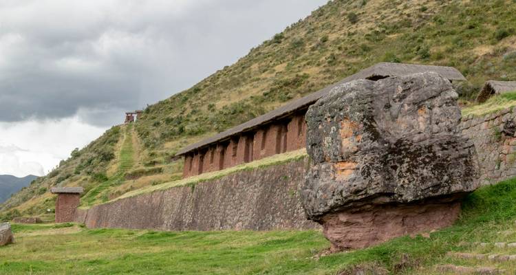 Stenen constructie met een grote rotsblok ervoor.