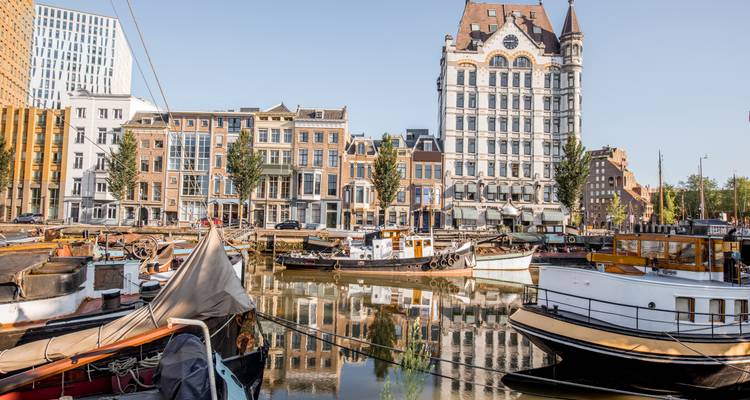 Schöner Hafen mit historischen Gebäuden und Booten, die sich im Wasser spiegeln.