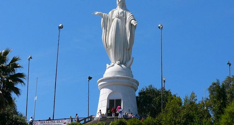 Statue de la Vierge Marie au sommet du Cerro San Cristóbal avec des visiteurs rassemblés sur la plateforme d'observation.