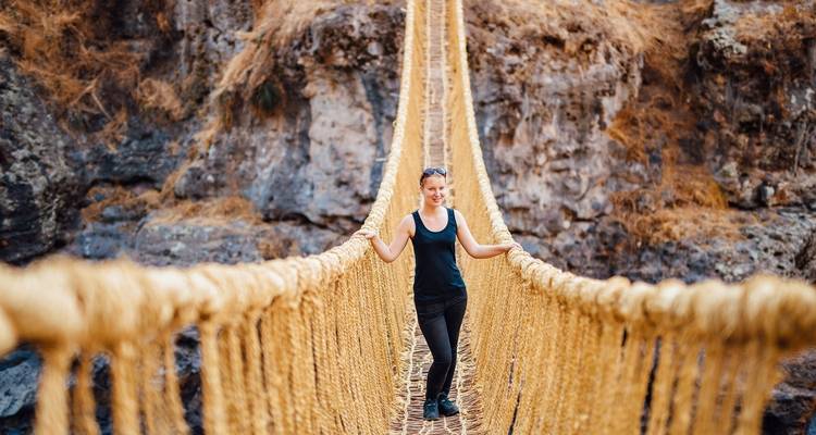 Persoon die zelfverzekerd op een hangbrug staat.