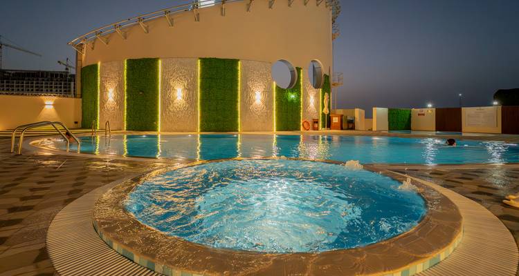 Une piscine sur le toit avec bassin circulaire décoratif et ambiance nocturne.