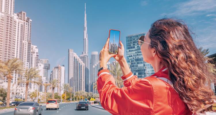 Une femme prenant une photo du Burj Khalifa et du paysage urbain de Dubaï.