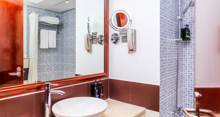 Une salle de bain d'hôtel propre avec des équipements modernes et un grand miroir.