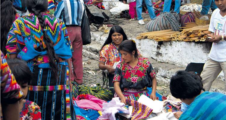 Vrouwen die kleurrijke textiel verkopen op een levendige markt.