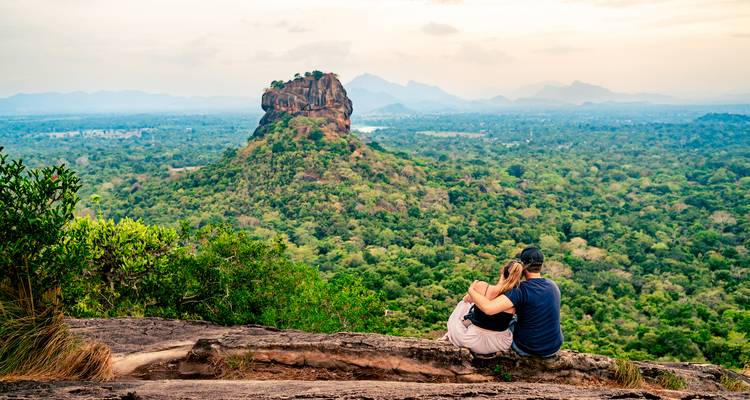 Paar auf einem Felsen mit Blick auf den Sigiriya-Felsen in der Ferne.
