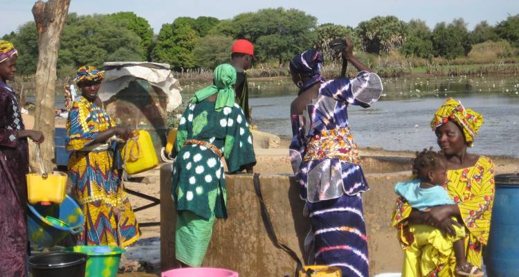 Femmes en vêtements traditionnels colorés allant chercher de l'eau.