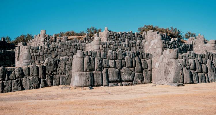 Massive ineinandergreifende Steinmauern der Inka-Festung Saqsaywaman unter einem klaren blauen Himmel.