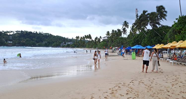 Scène de plage avec des gens se promenant et se relaxant.