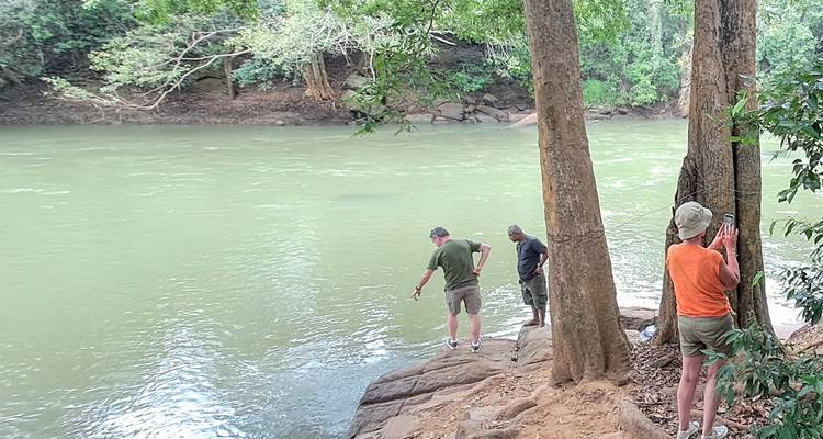 People standing by a riverbank.