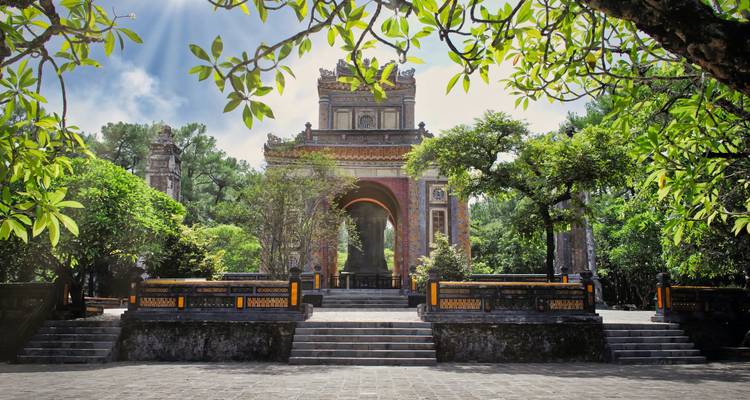 Historische tempel omgeven door weelderige bomen en trappen die er naartoe leiden.