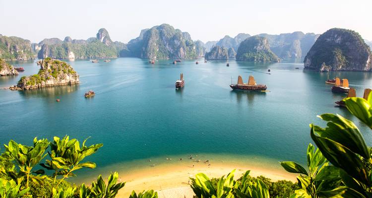 Panoramisch uitzicht op Halong Bay met traditionele boten.