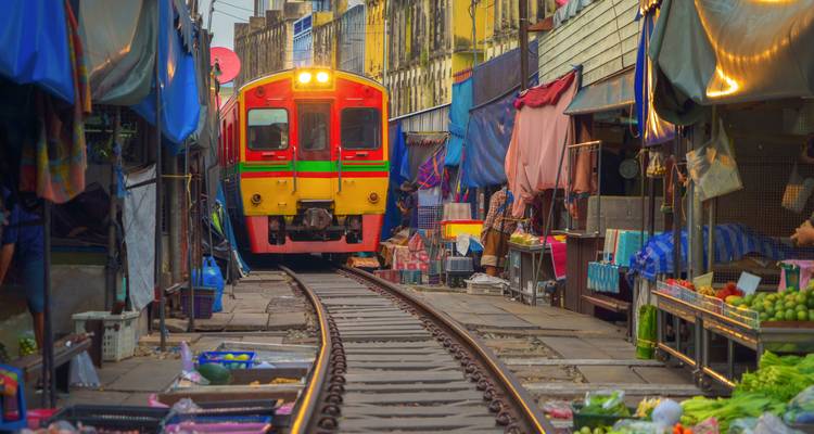 Trein die door een drukke marktplaats rijdt.