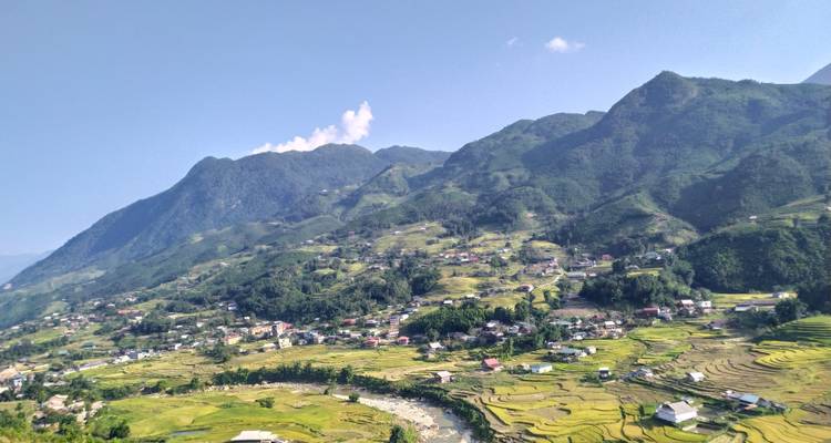 Vue panoramique d'une vallée avec des rizières et des montagnes.