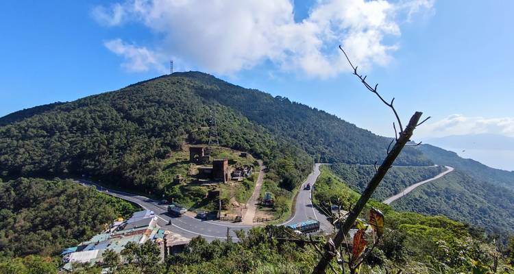 Route vallonnée avec des ruines et un environnement verdoyant luxuriant.