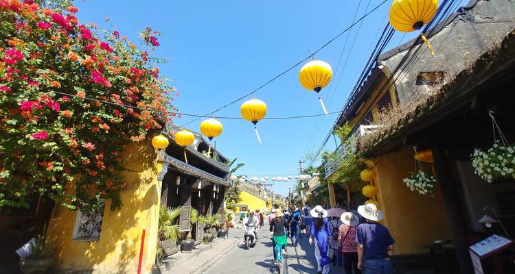 Rue avec des lanternes suspendues et des touristes.