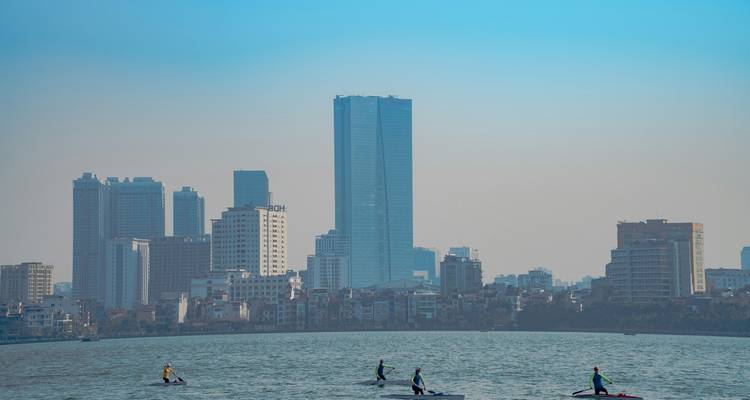 Stadtsilhouette mit Hochhäusern und einem Fluss im Vordergrund.