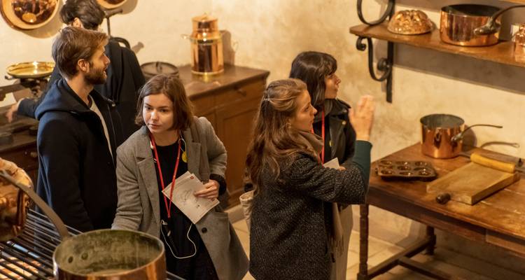 Visitors exploring the interior of an old castle kitchen.