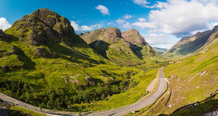 Une vue panoramique de la vallée de Glencoe avec des montagnes spectaculaires et une route.