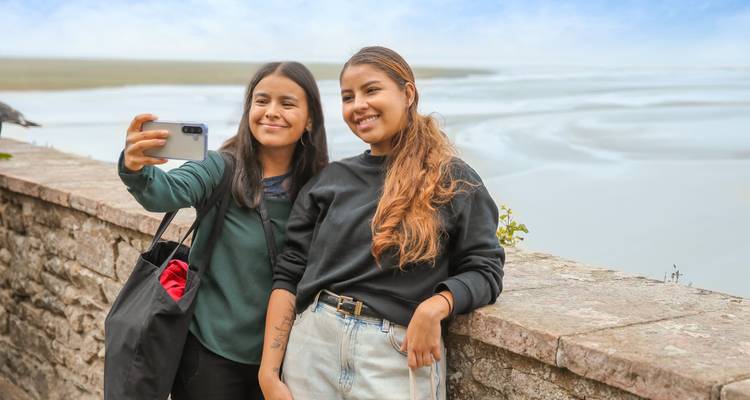 Deux touristes prenant un selfie avec un arrière-plan pittoresque