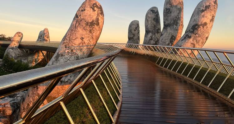 Gouden Brug met gigantische stenen handen bij zonsondergang.