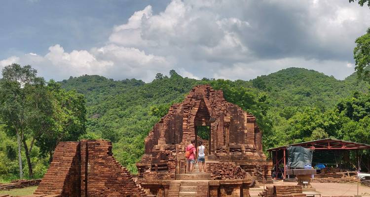Bezoekers die oude rode bakstenen ruïnes verkennen.