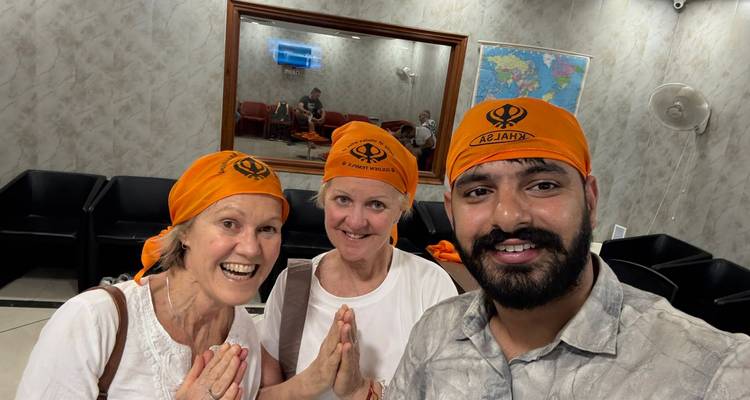 Tres personas posando con pañuelos naranjas en la cabeza y una sonrisa.