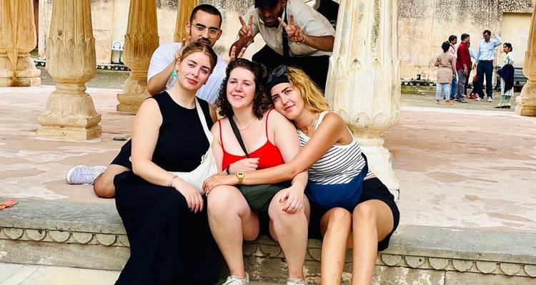 Grupo sentado en la base de grandes pilares.