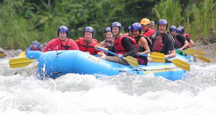Rafting en groupe à travers les rapides avec une végétation luxuriante.